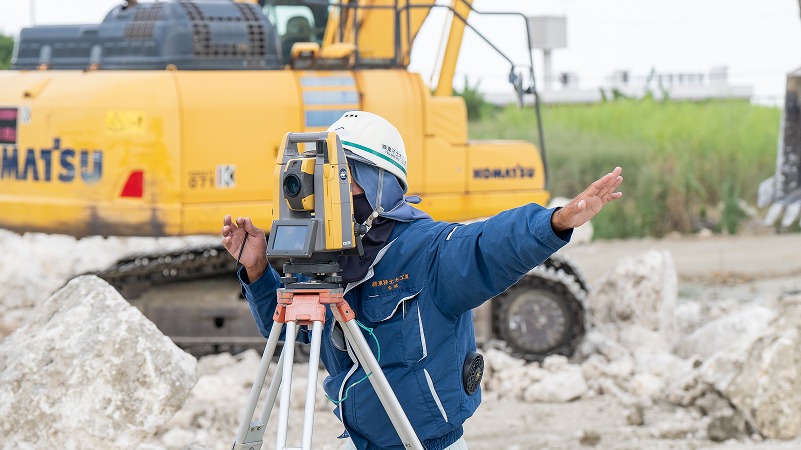 現場で測量を行う社員